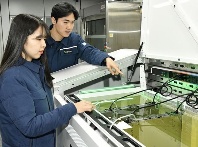  HD현대오일뱅크 직원들이 액침 냉각 설비에 담긴 냉각 윤활유와 서버를 테스트하는 모습. /사진=HD현대오일뱅크