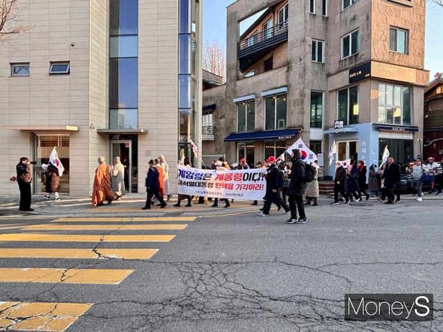 윤석열 대통령에 대한 탄핵심판일이 아직 공표되지 않은 가운데 탄핵을 찬성하는 쪽과 반대하는 쪽의 집회가 점점 심화하고 있다. 사진은 윤 대통령의 탄핵을 반대하는 시민들이 현수막을 들고 북촌 골목에서부터 헌법재판소까지 행진하는 모습. /사진=박세희 기자