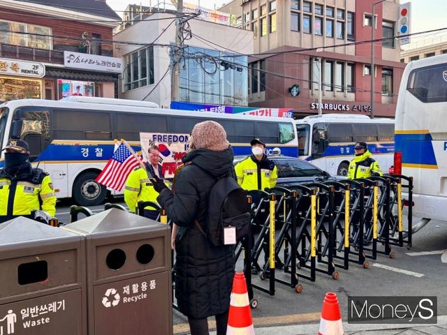 지난 19일 오후 안국역 사거리에서부터 헌법재판소까지 이어진 경찰의 차 벽들 사이에서 경찰관이 도로를 통제하고 있다. /사진=박세희 기자