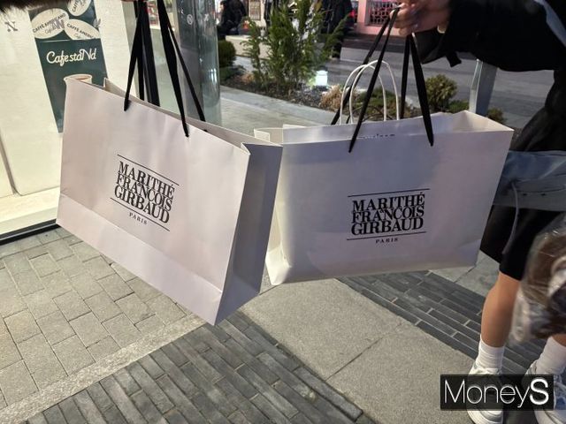 성수동에서 제품을 구매한 일본인 관광객이 쇼핑백을 들어올려 보이고 있다. /사진=조승희 기자 