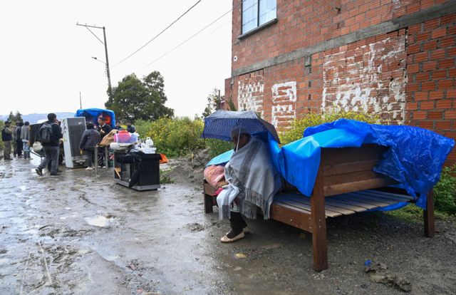 극심한 폭우로 남미 볼리비아의 90개 도시가 재난 지역으로 선포됐다. 사진은 지난 10일 볼리비아 라파스 코다비사 지역에서 폭우로 인한 산사태로 집이 무너져 피해를 입은 여성이 우산을 쓰고 앉아있는 모습. /사진=로이터