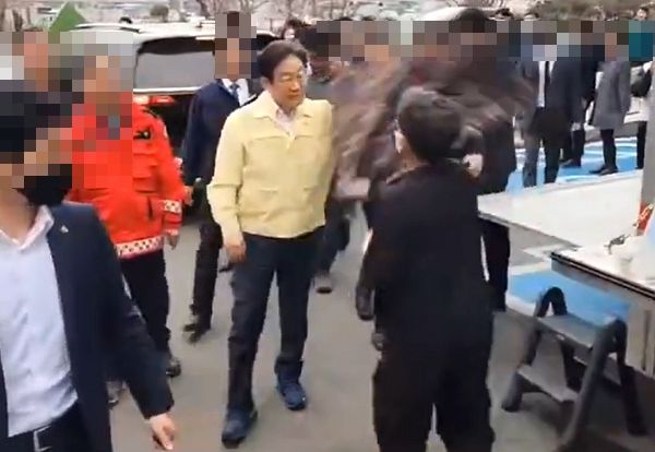 이재명 더불어민주당 대표가 경북 산불 현장에서 이재민을 위로하다 검은 옷 남성에게 위협 당했다. 사진은 검은 옷을 입은 남성이 이재명 더불어민주당 대표를 옷으로 위협하는 모습. /사진=엑스(X·옛 트위터) 캡처