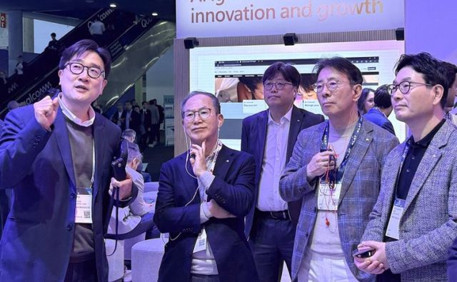 KB금융그룹 양종희 회장(왼쪽 두 번째),이창권 디지털·IT부문장(왼쪽 다섯 번째),이재근 글로벌 사업부문장(왼쪽 네 번째)이 지난 5일(현지시간) 스페인 바로셀로나에서 열린 'MWC25' 행사장에서 설명을 듣고 있다. /사진=KB금융 제공 