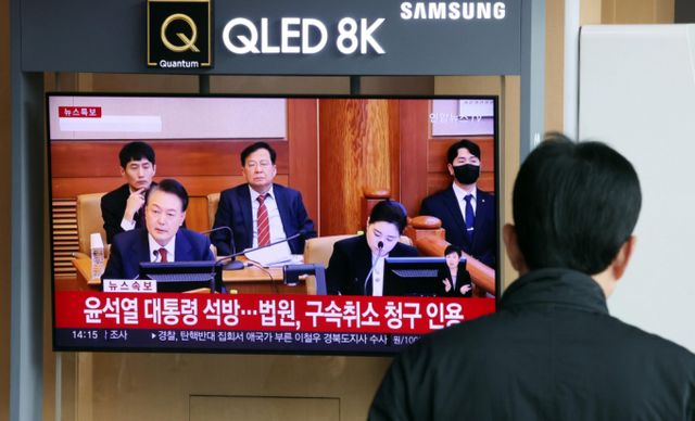 윤석열 대통령 측이 법원의 구속취소를 인용한 서울중앙지법의 결정대로 검찰은 속히 대통령을 석방해야 한다고 주장했다. 사진은 인천 중구 서울역대합실을 이용하는 고객들이 윤석열 대통령 구속취소 청구가 인용된 사실을 뉴스르 보고 있는 모습. /사진=뉴시스