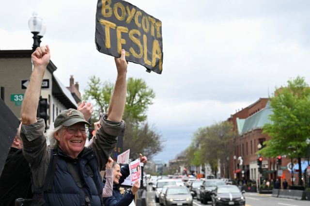사진은 지난 12일 미국 워싱턴DC 조지타운 지역의 테슬라 대리점 밖에서 테슬라 불매운동 피켓을 든 시위대 모습. /사진=로이터