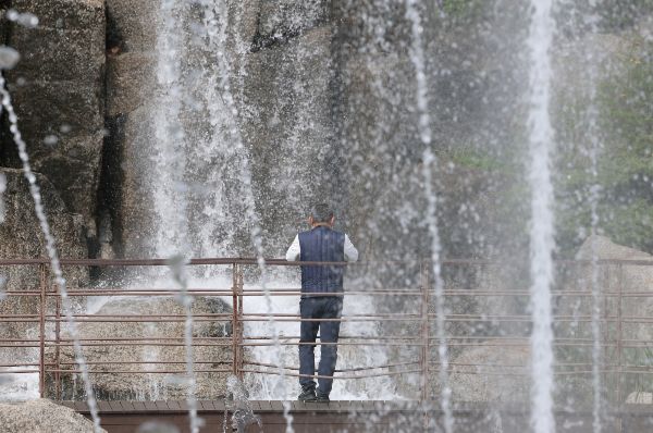 오는 22일은 전국이 대체로 흐리고 새벽부터 비가 내리기 시작하겠다. 사진은 낮 최고기온이 26도까지 오르는 등 따뜻한 초여름 날씨를 보인 21일 경기 안산시 상록구 노적봉인공폭포공원을 찾은 시민이 시원한 폭포를 바라보고 있는 모습. /사진=뉴스1