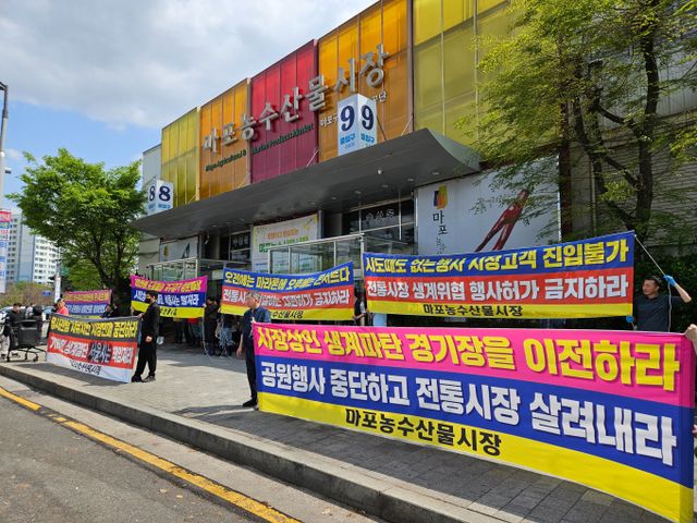 서울 마포농수산물시장 상인들이 서울 도심에서 열리는 마라톤으로 인해 생계에 방해를 받고 있다고 주장하며 지자체에 대책 마련을 촉구했다. 사진은 21일 서울 마포농수산물시장 상인 50여명이 성산동 시장 정문에서 기자회견을 연 모습. /사진=뉴시스