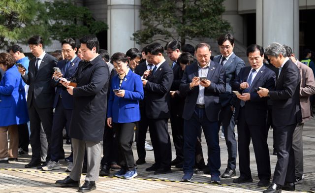 이재명 더불어민주당 대선 경선 후보의 공직선거법 위반 사건이 대법원 전원합의체로 직행한 가운데 판결 시점과 내용에 따라 이 후보의 향후 대선 행보에 중대한 영향을 미칠 수 있다는 관측이 나온다. 사진은 더불어민주당 의원이 지난달 26일 서울 서초구 서울고등법원에서 열린 이재명 더불어민주당 대표 공직선거법 위반 혐의 항소심 선고 공판 결과를 기다리며 휴대폰을 보고 있는 모습. /사진=뉴스1(공동취재단)