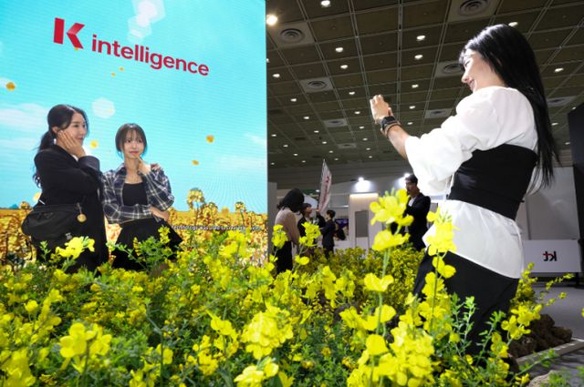 KT 모델들이 KT 2025 월드IT쇼 전시부스에서 각종 AI 기술을 체험하고 있다. /사진=KT
