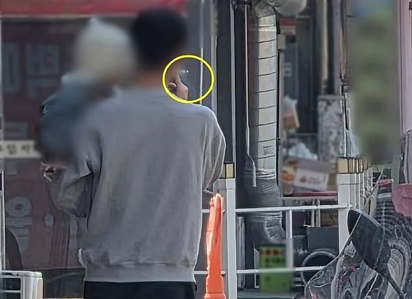 아기를 안은 채 아무렇지 않게 길거리에서 흡연하는 남성의 모습이 포착됐다. 사진은 한 남성이 길거리에서 아기를 안은 채 흡연하는 모습. /사진=온라인커뮤니티 '보배드림' 캡처
