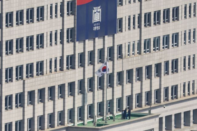 헌법재판소의 윤석열 대통령 탄핵이 인용된 4일 서울 용산구 대통령실에서 대통령실 관계자들이 봉황기를 내리고 있다. / 사진=사진공동취재단 