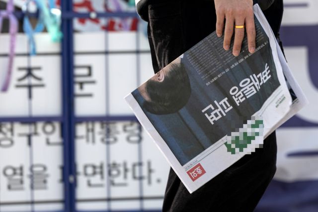 외교부가 윤석열 대통령에 대한 탄핵이 인용된 후 한덕수 대통령 권한대행의 지시와 당부를 전파했다. 사진은 4일 서울 종로구 서십자각터 인근 한 시민이 윤석열 대통령에 대한 탄핵소추안이 인용된 내용을 담은 신문 호외를 들고 있는 모습. /사진=뉴스1 