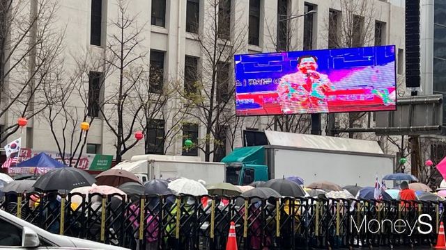 광화문에서 보수 진영이 탄핵 무효 집회를 열었다. 사진은 연단에 선 발언자를 생중계하는 전광판과 우산을 쓴 참가자들의 모습. /사진=박은서 기자