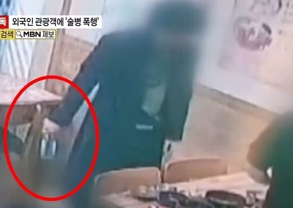 경찰이 서울 한복판에서 모르는 타이완 관광객을 술병으로 폭행한 남성을 쫓고 있다. 사진은 가해 남성이 식탁 위에 있던 술병을 들고 나가는 모습. /사진=MBN 캡처