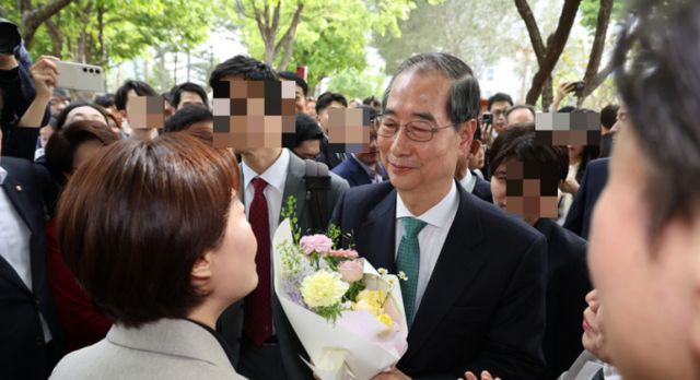 한덕수 전 국무총리가 지난 8일 김문수 국민의힘 대통령 후보와의 단일화 회동을 위해 서울 여의도 국회 강변서재로 향하다 꽃다발을 받고 있다. /사진=뉴스1(공동취재단)