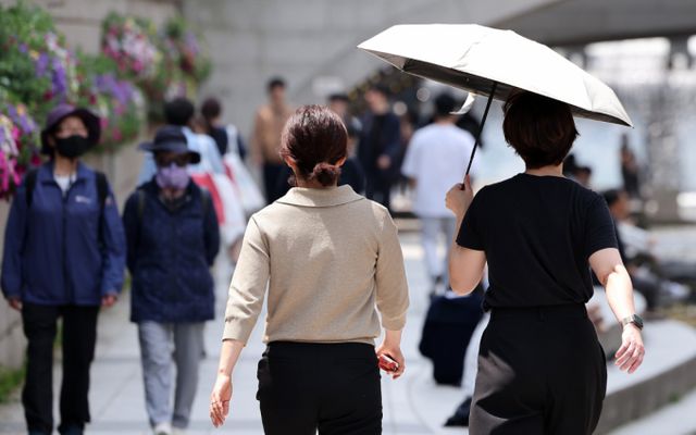 18일 전국 교통량이 평소 일요일보다 증가할 것으로 보인다. 서울 낮 최고 온도 25도를 기록하며 초여름 날씨를 보인 지난 13일 서울 중구 청계천을 찾은 시민들이 햇빛을 가린 채 이동하는 모습. /사진=뉴스1