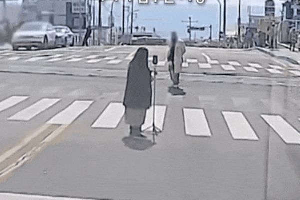 도로 한복판에서 차량 주행을 막고 인생샷을 건지려는 민폐 관광객 모습이 공개됐다. 사진은 부산 해운대구 청사포 해변 인근 도로 한복판에서 사진을 찍는 커플 모습. /사진=보배드림 캡처