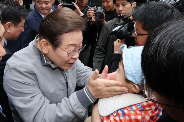 민심 청취 '경청 투어'에 나선 이재명 더불어민주당 대선 후보가 3일 강원 속초중앙시장에서 아기에게 인사하고 있다. /사진=속초 뉴시스 조성우 기자