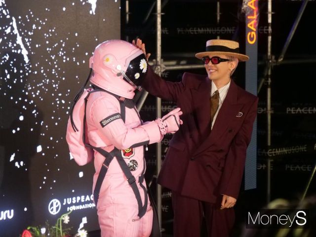 CU와 지드래곤의 협업으로 탄생한 피스마이너스원 하이볼 시리즈가 아트 하이볼 출시로 정점을 찍었다. 13일 서울 용산구 한남동 그랜드 하얏트 호텔 수영장에서 열린 행사에서 지드래곤이 분홍색 우주복 차림의 마스코트와 함께 포즈를 취하는 모습. /사진=이수빈 기자