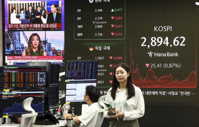 코스피가 전 거래일(2920.03)보다 25.41포인트(0.87%) 떨어진 2894.62에 장을 마친 13일 서울 중구 하나은행 본점 딜링룸에 이스라엘과 이란 전쟁 관련 뉴스가 나오고 있다. /사진=뉴시스