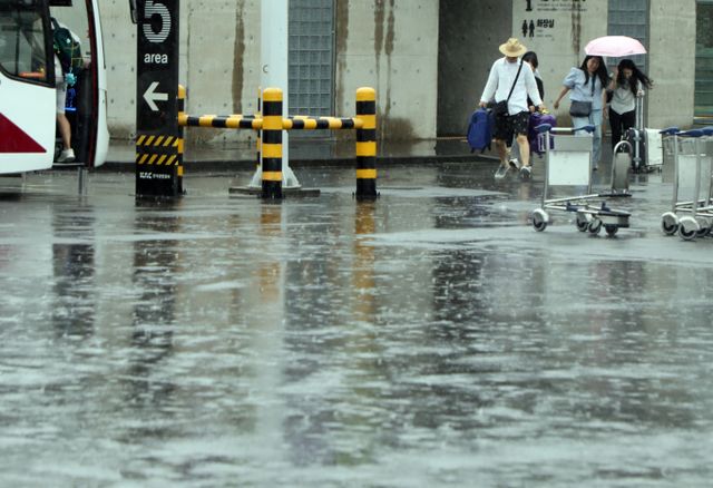 19일 전국이 대체로 흐리고 오후부터 비가 내릴 전망이다. 사진은 지난 16일 제주시 제주국제공항에서 관광객들이 비를 피하는 모습. /사진=뉴스1