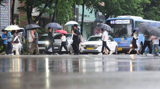 행정안전부는 수도권과 강원도 등 중부지방을 중심으로 많은 비가 내림에 따라 20일 오후 2시30분을 기해 중앙재난안전대책본부 1단계를 가동했다고 밝혔다. 사진은 본격적인 장마가 시작된 20일 서울 여의도역 인근에서 시민들이 우산을 쓰고 있는 모습. /사진=뉴시