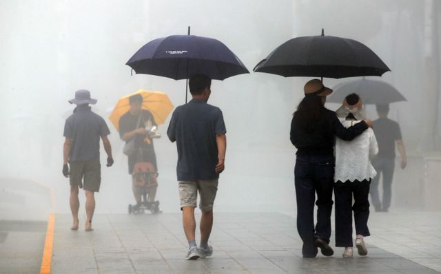 오는 21일 전국을 강타한 장맛비가 수도권과 중부지방을 시작으로 멈출 전망이다. 사진은 지난 20일 부산 해운대해수욕을 지나는 시민들의 모습. /사진=뉴스1 