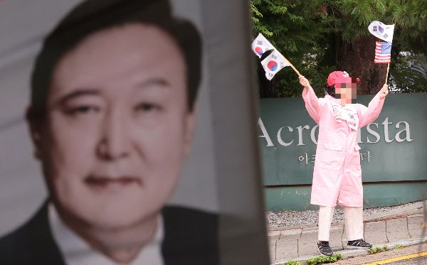 윤석열 전 대통령 체포영장 기각 소식에 지지자들이 크게 환호했다. 사진은 서울 서초구 아크로비스타 윤석열 전 대통령 사저 앞에서 한 지지자가 태극기를 흔들고 있는 모습. /사진=뉴스1