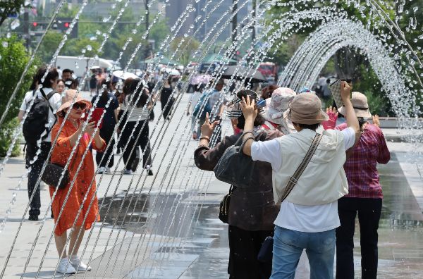 27일은 내륙을 중심으로 낮 기온이 30도 이상 오르겠다. 사진은 최고기온이 30도를 넘으며 무더위가 이어진 지난 18일 서울 종로구 광화문광장 바닥분수로 시민들이 지나가고 있는 모습. /사진=뉴스1