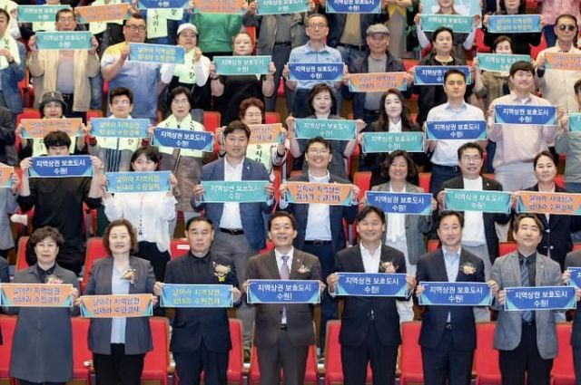 지난 5월1일 ‘지역상권 보호도시, 수원’ 선포식에서 이재준 수원특례시장과 관계자, 상인, 시민 등이 비전을 들어 보이고 있다.