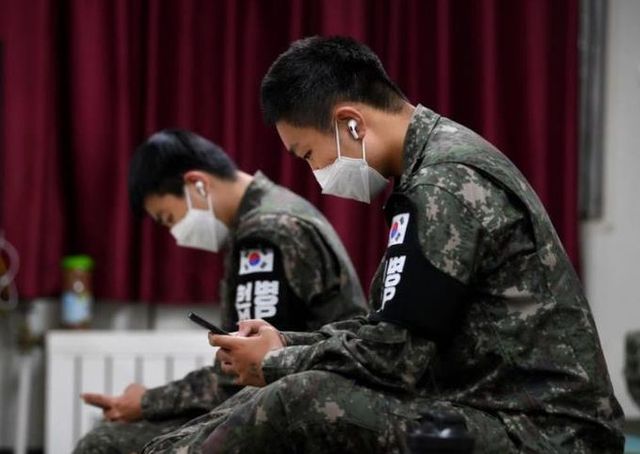 일과 후 이어폰을 착용하고 휴대전화를 사용 중인 병사들의 모습. 국방일보 제공
