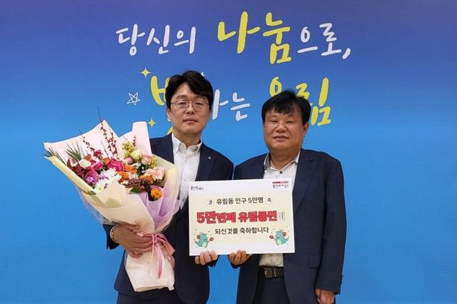 지난달 28일 처인구 유림동의 5만번째 주민이 된 권병손씨(왼쪽)가 기념촬영을 하고 있다.