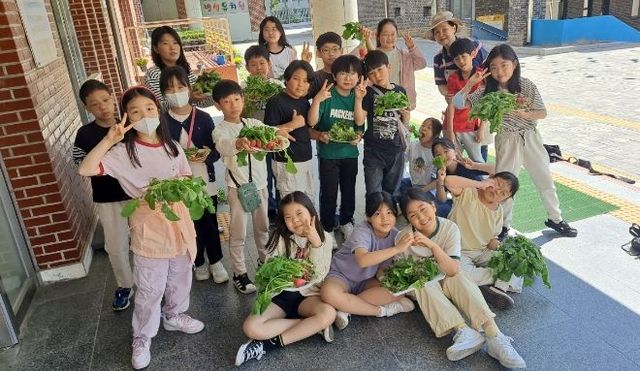 용인특례시 처인구 이동읍 용천초 학생들이 수확 후 기념촬영을 하고 있다