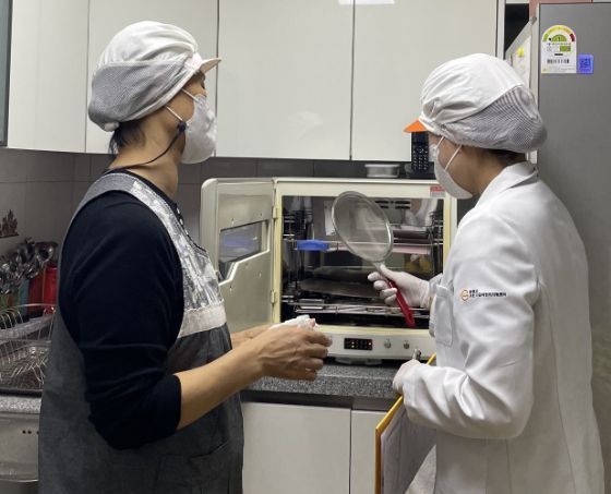 어린이 기호식품 전담관리원이 어린이집 집단급식소에서 위생 점검을 실시하고 있다.