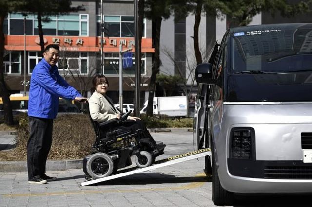 유니버설디자인이 적용 된 특별교통수단에 휠체어 승객이 탑승하고 있다.