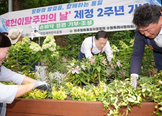 이재준 수원시장이 참석자들과 함께 정원을 조성하고 있다.