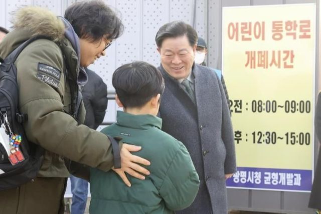 박승원 광명시장이 지난 3월 광명초등학교 광이로 임시 통학로를 점검하러 나서 등교하는 학생과 인사를 나누고 있다.