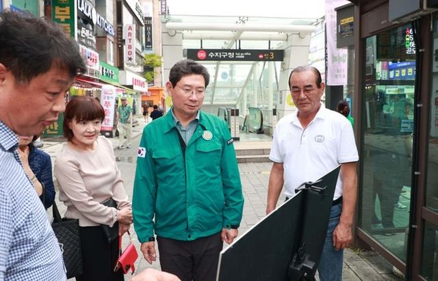 이상일 용인특례시장이 14일 수지구청역 버스정류장에서 노후차량 교체와 정류장 확장 계획을 보고받고 있다