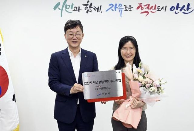 이민근 안산시장(왼쪽)이 백은정 ㈜아트블러드 대표에게 '안산시 청년창업 펀드 3호 투자기업' 현판을 전달하고 있다.