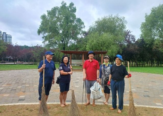 이택수 경기도의원이 주민들과 함께 고봉산 기슭 건강숲길 및 황토체험장 조성사업 현장 점검에 이어 맨발로 걸으며 쓰레기 청소 및 낙엽쓸기 운동을 벌이고 있다.