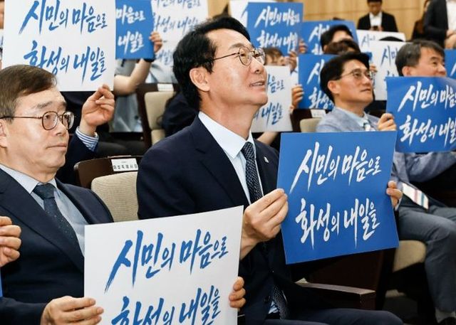 정명근 화성특례시장을 비롯한 참석자들이 '시민의 마음으로 화성의 내일을' 문구를 들어 보이며 화성미래비전위원회의 성공적인 출범 의지를 다지고 있다.