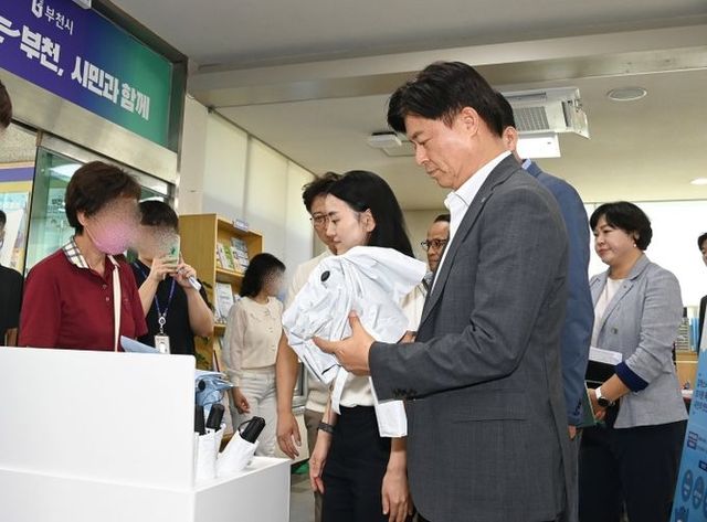 조용익 부천시장이 지난해 행정복지센터에 들러 ‘폭염 속 그늘’ 양우산 무료 대여사업을 살펴보고 있다.