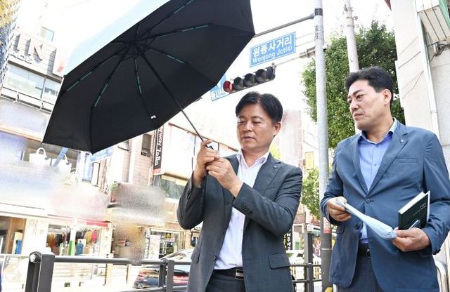 조용익 부천시장(왼쪽)이 ‘폭염 속 그늘’ 사업에 사용되는 우산을 꼼꼼히 살펴보고 있다.