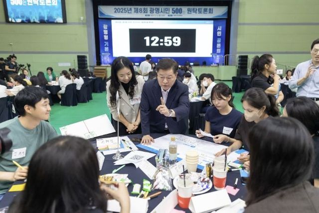 박승원 광명시장이 지난 2025년 9월 광명시민체육관에서 열린 '제8회 광명시민 500인 원탁토론회'에 참가한 시민들과 기본사회 정책에 대해 논의 하고 있다