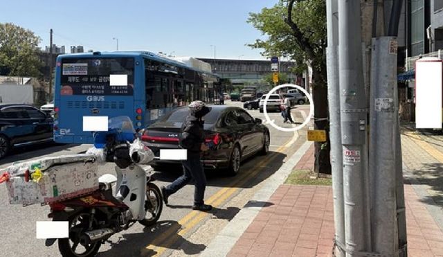 불법 주·정차 차량으로 인해 차로에서 승객이 승차하는 모습