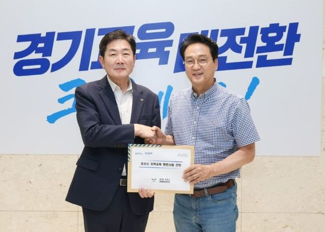 조용호 오산시장이 4일 경기도교육청에서 안민석 경기도교육감에게 오산시 지역교육 현안사업 건의서를 전달하고 있다.