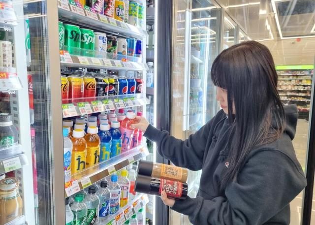 한 고객이 CU 매장에서 LF와 협업해 선보인 신제품 헤지스 음료를 살펴보고 있다 사진CU