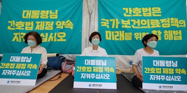 간호법 공포 촉구하며 단식 이어가는 간협 대표단 (서울=연합뉴스) 신현우 기자 = 대한간호협회(간협) 대표단이 14일 오전 서울 중구 간협 회관 앞에서 간호법 공포 촉구 단식 농성을 이어가며 손팻말을 들고 있다. 김영경 간협 회장 등 대표단은 지난 9일부터 간호법의 조속한 공포를 촉구하며 무기한 단식에 들어갔다. 김 회장은 단식 4일째인 12일 오후 건강악화로 국립중앙의료원 응급실로 이송됐다. 2023.5.14 nowwego@yna.co.kr/2023-05-14 14:40:10/ <저작권자 ⓒ 1980-2023 ㈜연합뉴스. 무단 전재 재배포 금지.>