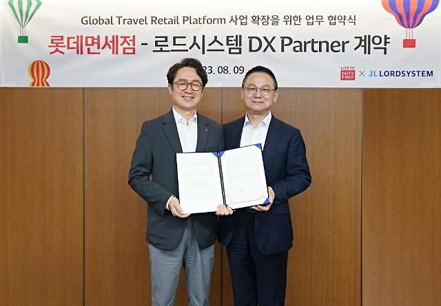 지난 9일 김주남 롯데면세점 대표이사사진 좌측와 장양호 로드시스템 대표이사가 계약 체결 후 기념사진을 촬영하고 있는 모습 