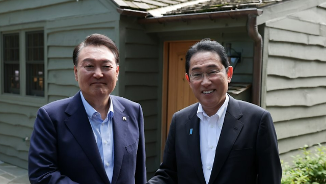 윤석열 대통령과 기시다 후미오 일본 총리가 18일현지시간 워싱턴DC 인근 미국 대통령 공식별장인 캠프 데이비드에서 한일 정상회담에서 악수하고 있다 사진연합뉴스